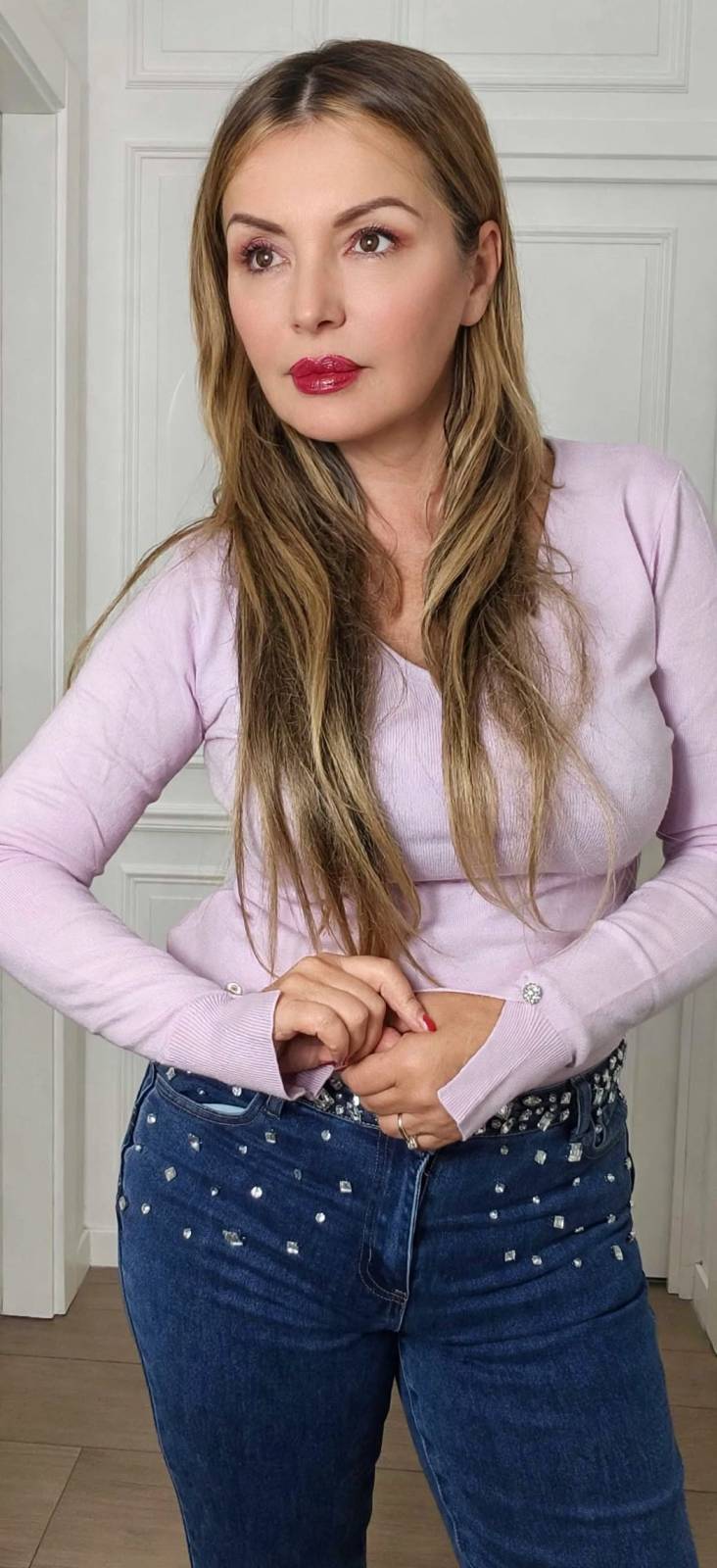 maglia rosa con bottoni gioielli e jeans con pietre